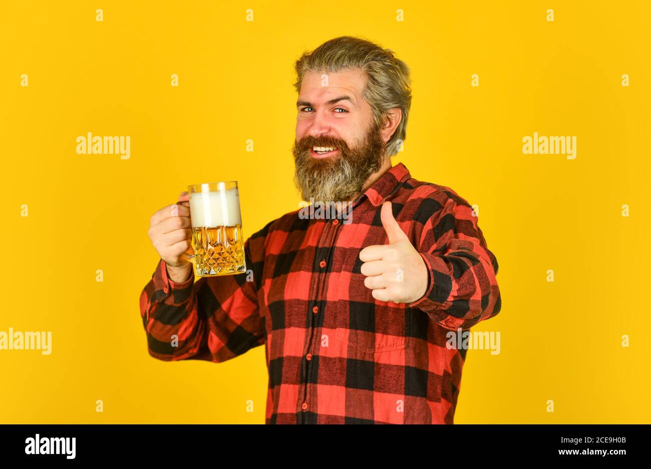 craft beer. Man drinking in pub bar. Beer with foam. brutal hipster drink beer. mature bearded barman hold beer glass. confident bartender raising toast. leisure and celebration. Stock Photo