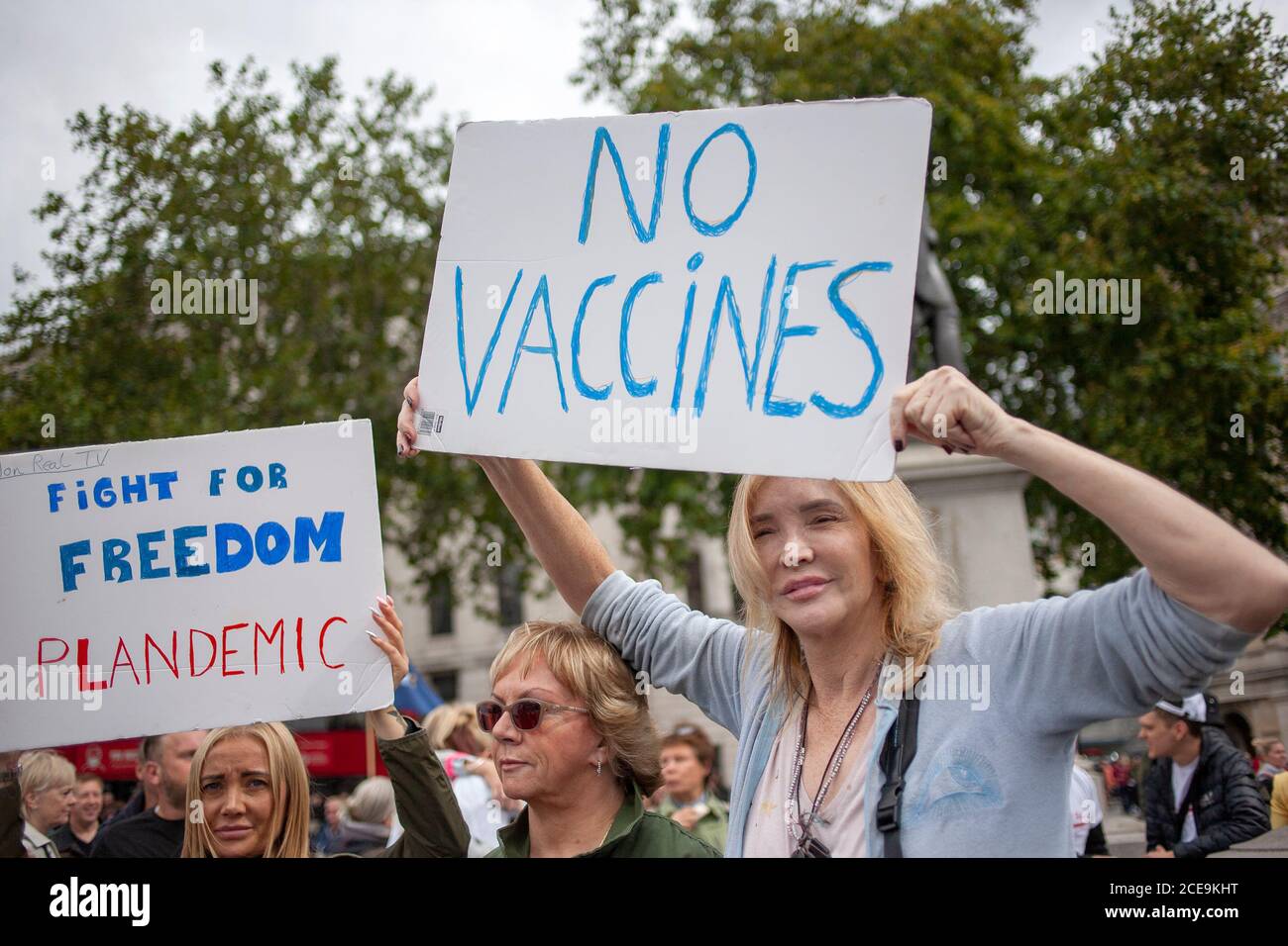 London, UK. 29th August 2020. A middle-aged blonde woman holds up a ‘No Vaccines’ banner. Unite for Freedom demonstration, Trafalgar Square. Stock Photo