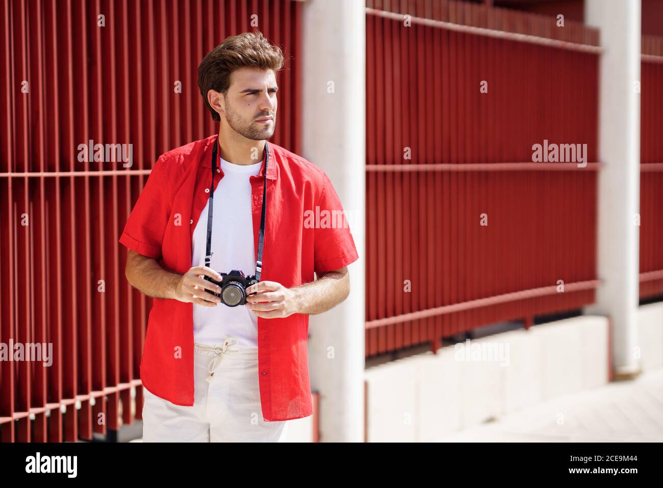 Millennial man taking photographs with a SLR camera Stock Photo - Alamy