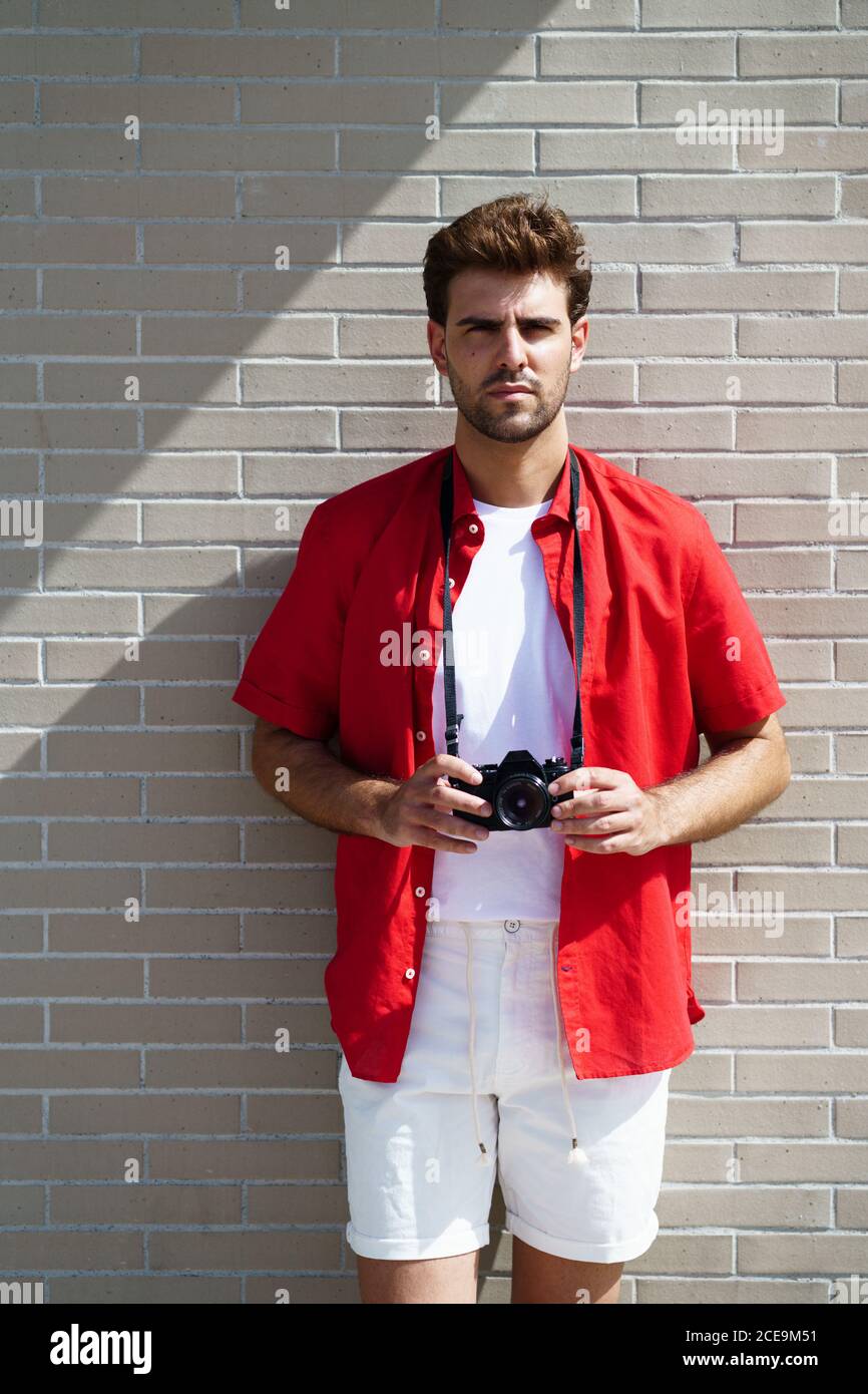 Millennial man taking photographs with a SLR camera Stock Photo - Alamy