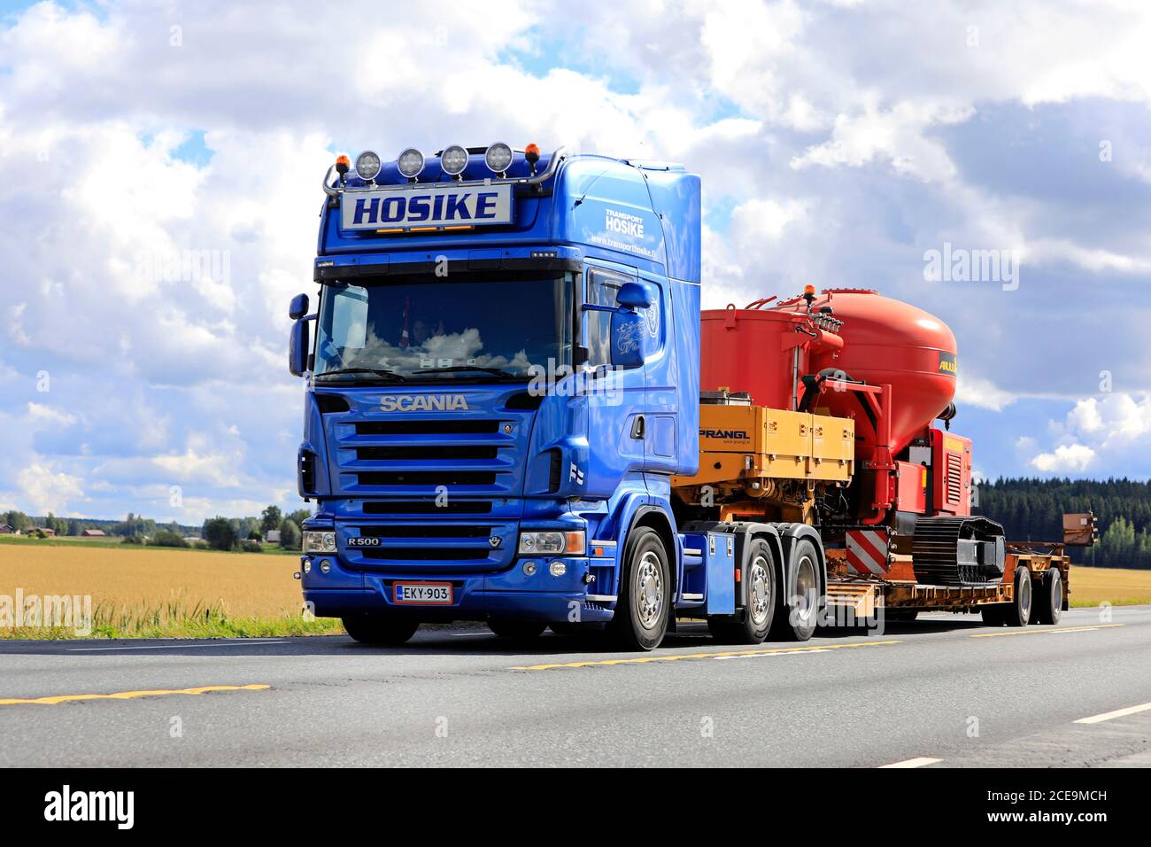 Blue Scania R500 semi trailer Hosike transports Allu PF Pressure Feeder as oversize load on highway 2 in autumn. Jokioinen, Finland. August 28, 2020. Stock Photo