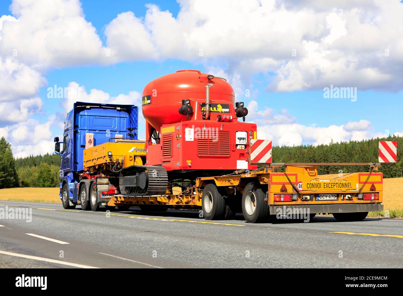 Blue Scania R500 semi trailer transports Allu PF Pressure Feeder as oversize load along highway 2 in autumn. Jokioinen, Finland. August 28, 2020. Stock Photo