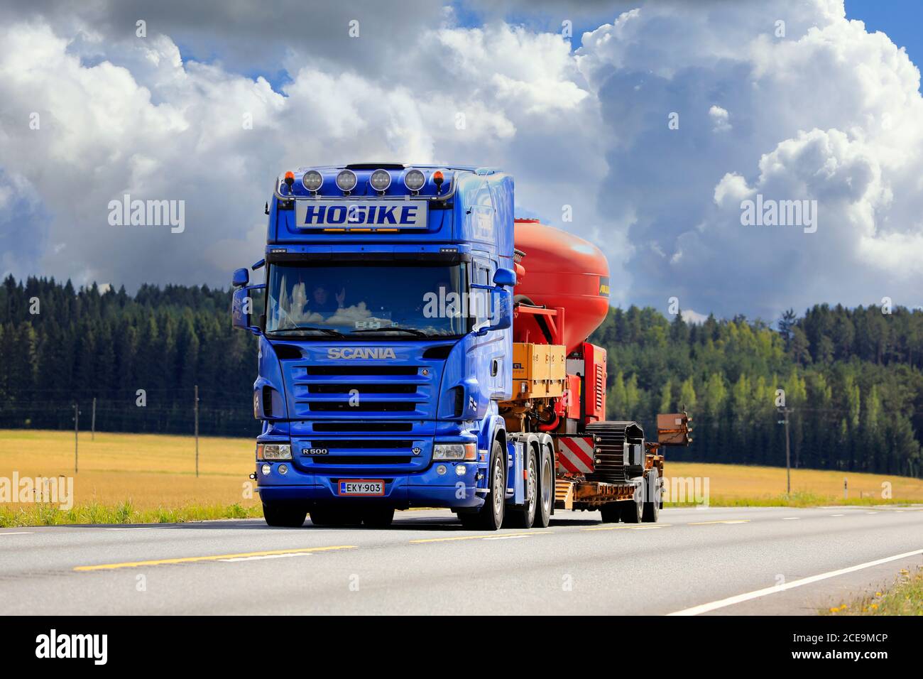 Blue Scania R500 semi trailer Hosike transports Allu PF Pressure Feeder as oversize load on highway 2 in autumn. Jokioinen, Finland. August 28, 2020. Stock Photo