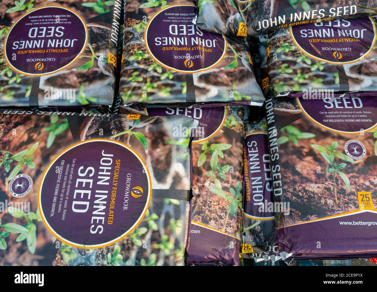 A stack of bags of Growmore John Innes seed sowing Compost in a farm shop Stock Photo
