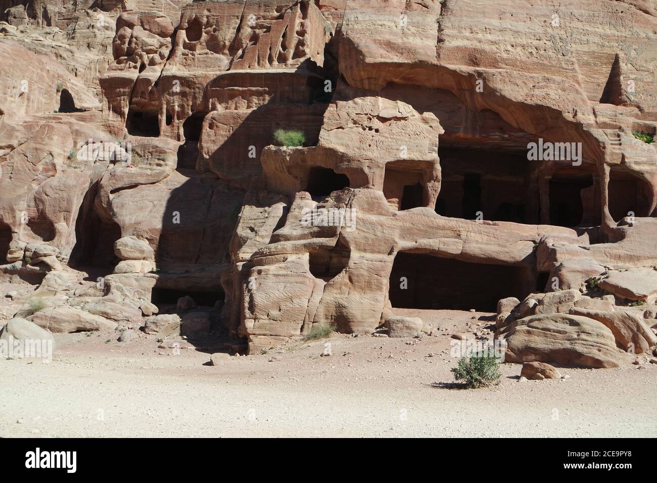 Caves in the rock wall of Petra, Jordan Stock Photo