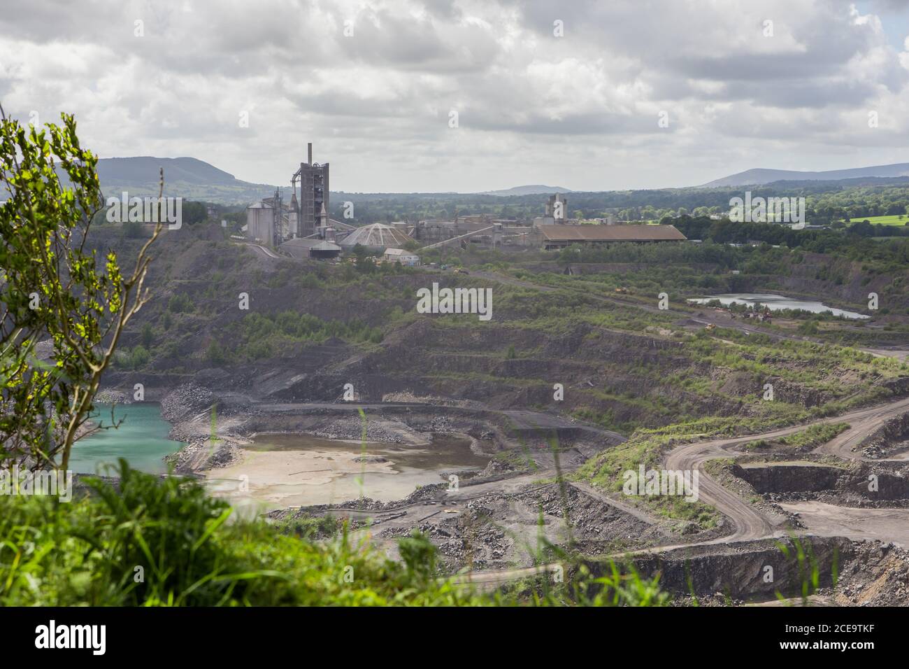 Large limestone quarry in Clitheroe, Ribble valley. Excavators and trucks working. Cement production Stock Photo