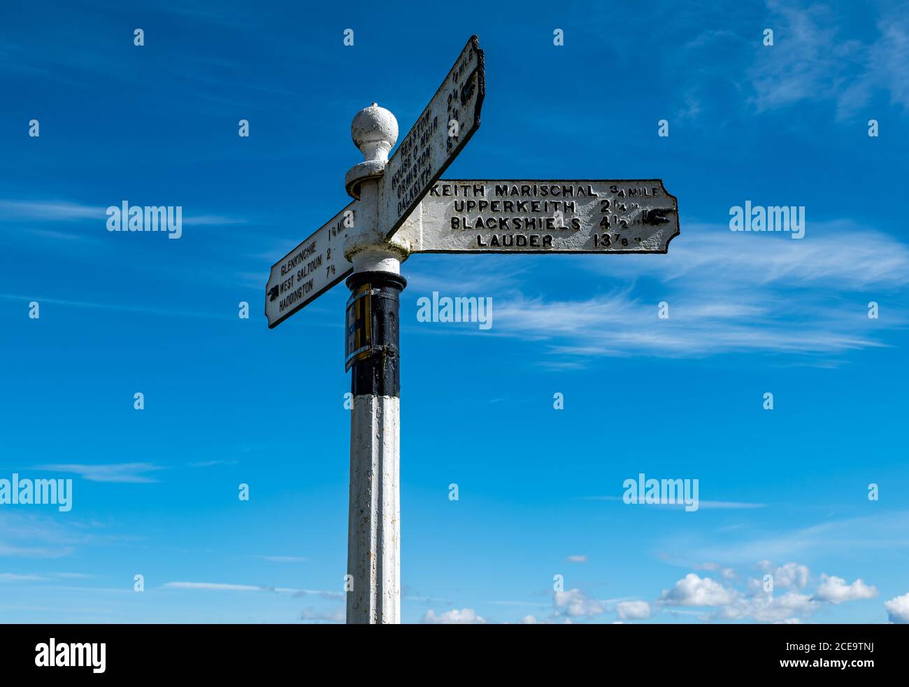 Old fashioned signpost with hand pointing to villages with distances in miles, East Lothian, Scotland, UK Stock Photo