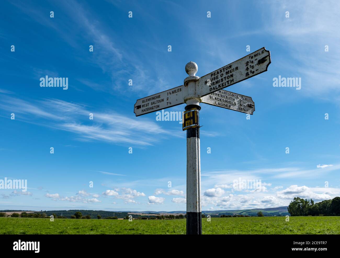 Old fashioned signpost with hand pointing to villages with distances in miles, East Lothian, Scotland, UK Stock Photo