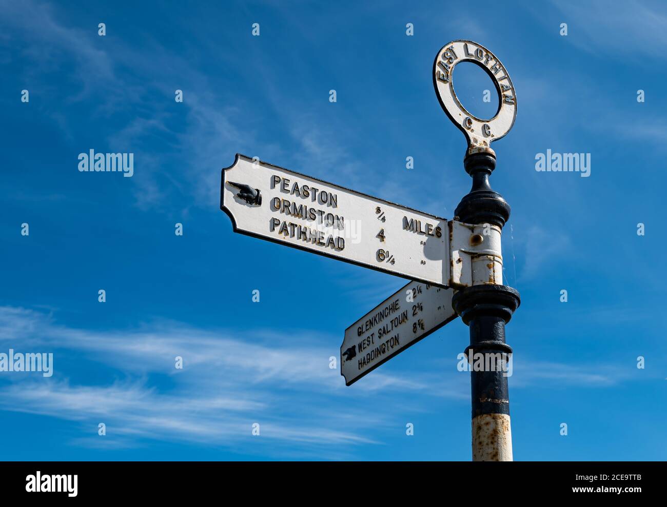 Old fashioned signpost with hand pointing io villages with distances in miles, East Lothian, Scotland, UK Stock Photo