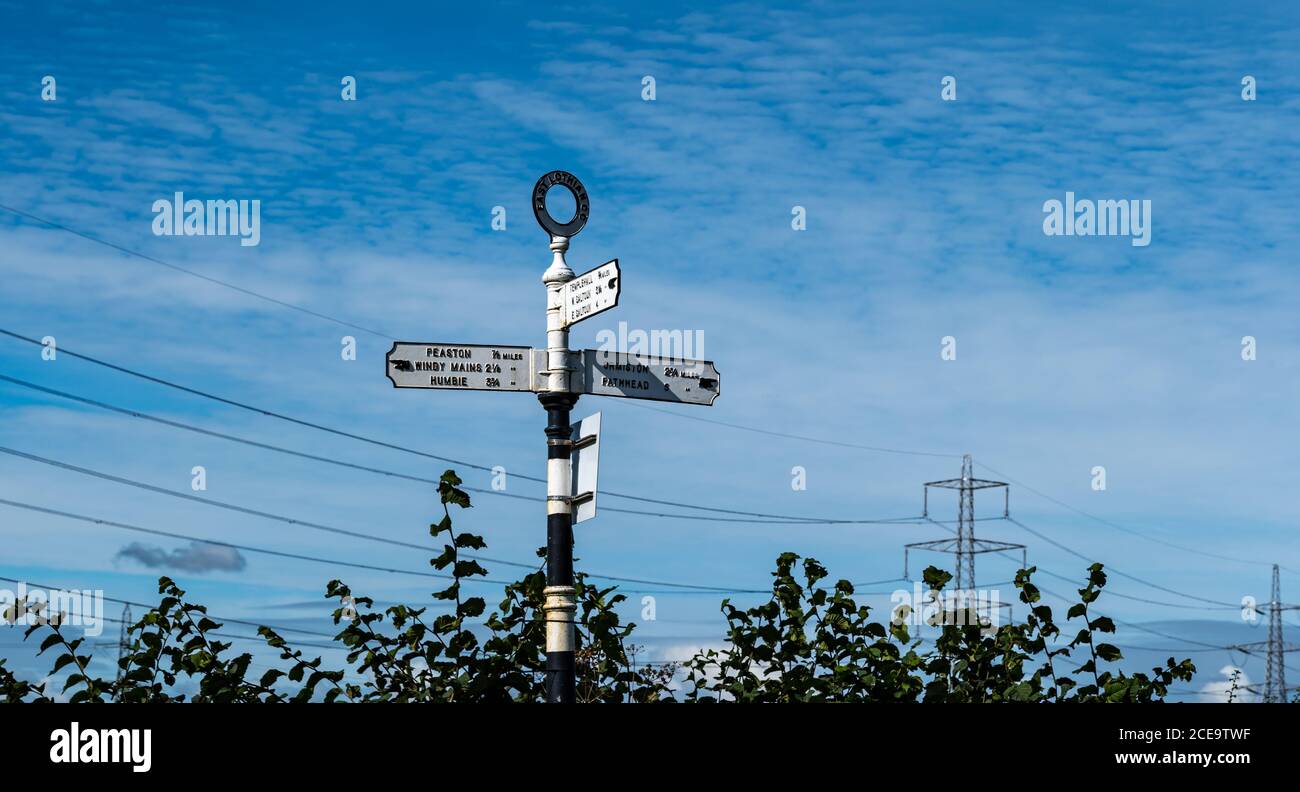 Old fashioned signpost with hand pointing to villages with distances in miles, East Lothian, Scotland, UK Stock Photo