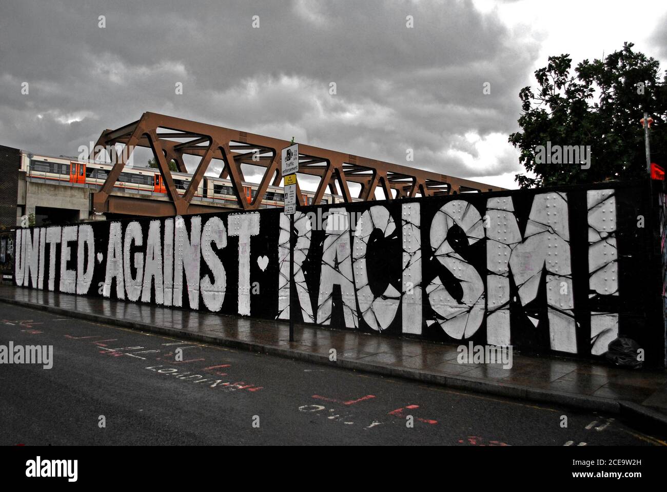 GRAFFITI LETTERING ON EAST LONDON'S BRICK LANE THAT READS UNITED AGAINST RACISM Stock Photo