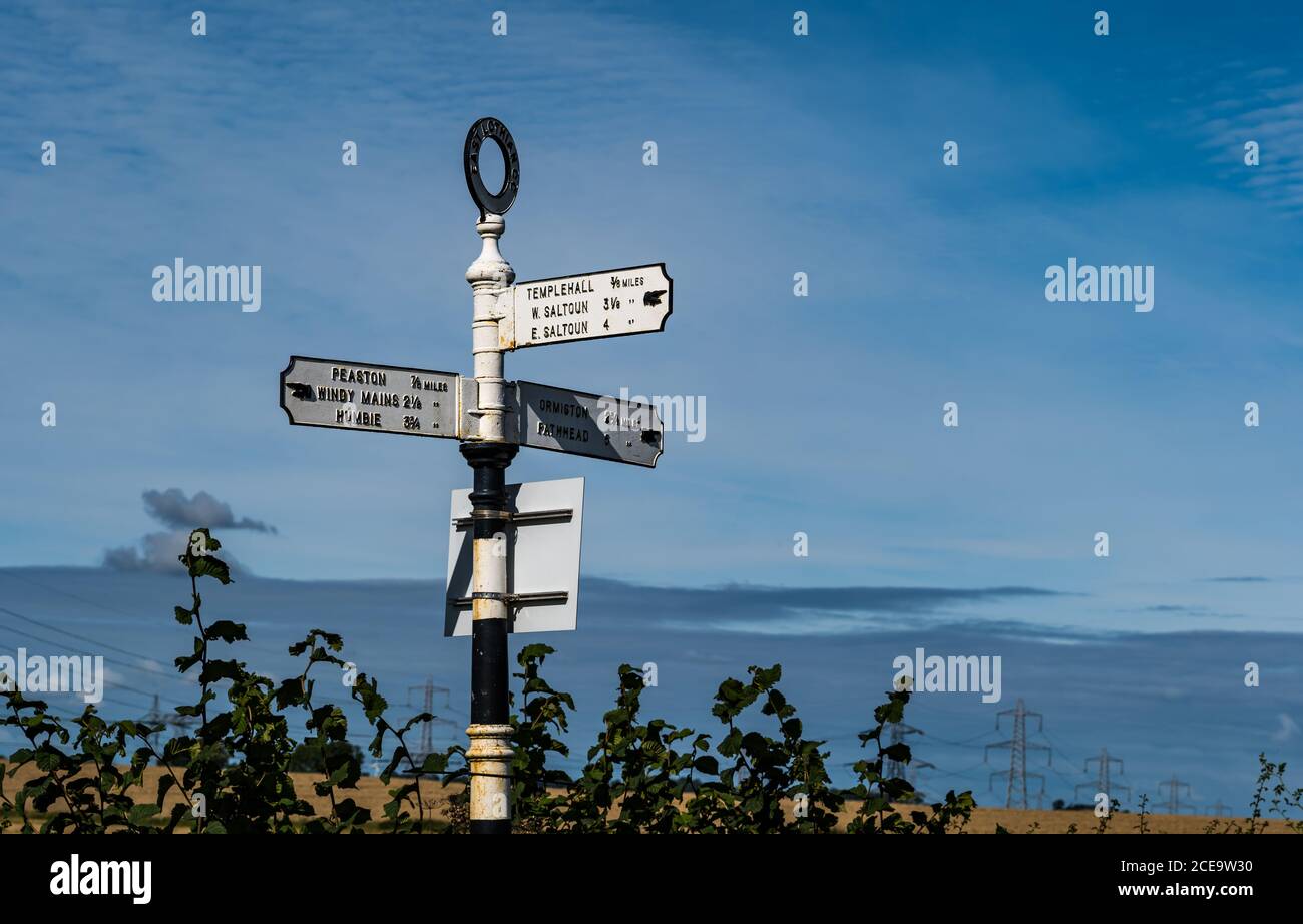 Old fashioned signpost with hand pointing io villages with distances in miles, East Lothian, Scotland, UK Stock Photo