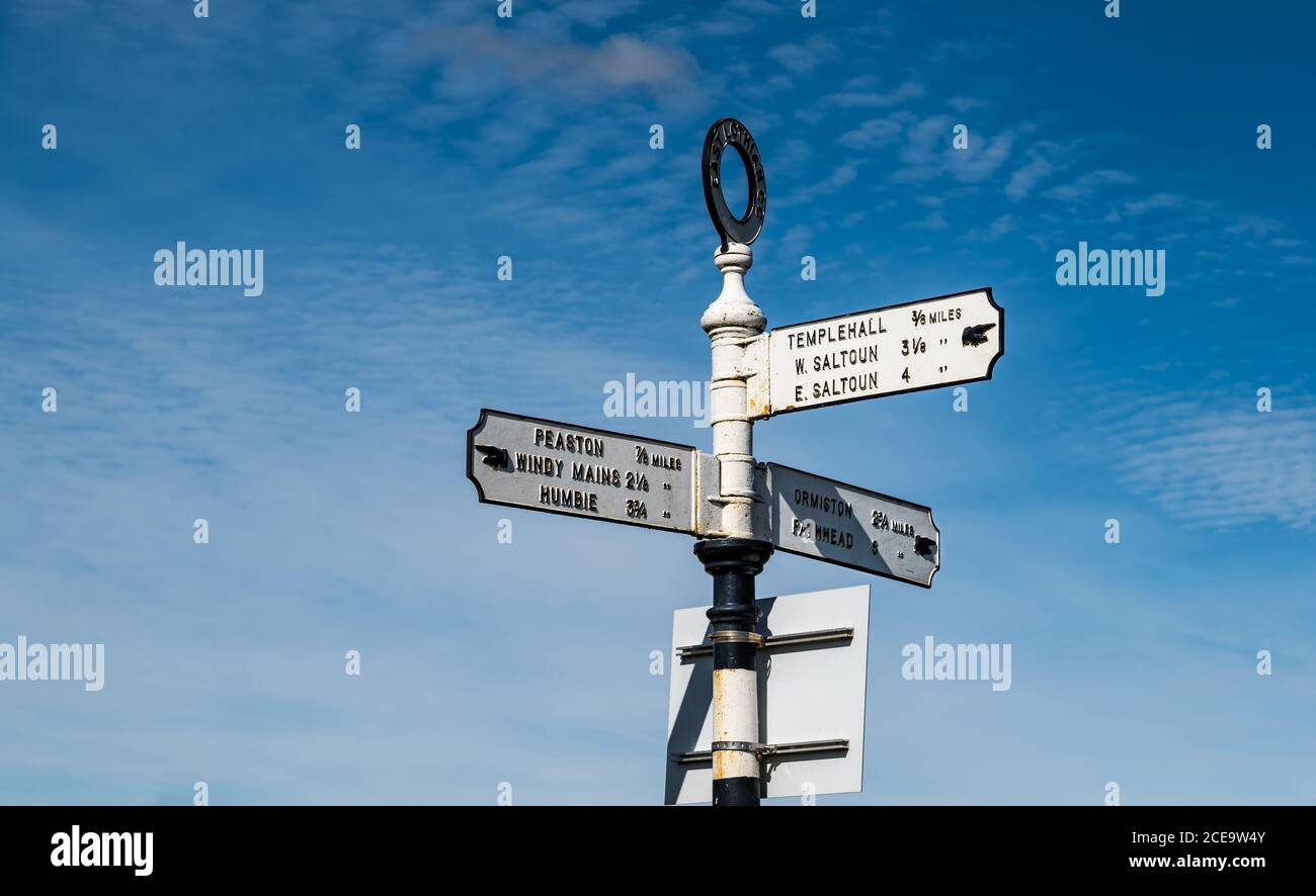 Old fashioned signpost with hand pointing io villages with distances in miles, East Lothian, Scotland, UK Stock Photo