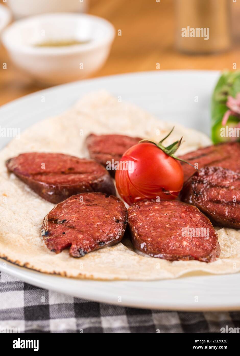 Sliced Turkish sausage on white plate cooked on the grill Stock Photo