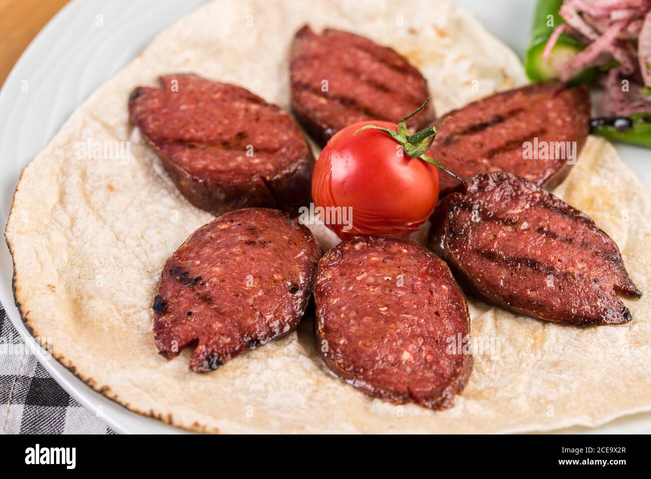 Sliced Turkish sausage on white plate cooked on the grill Stock Photo