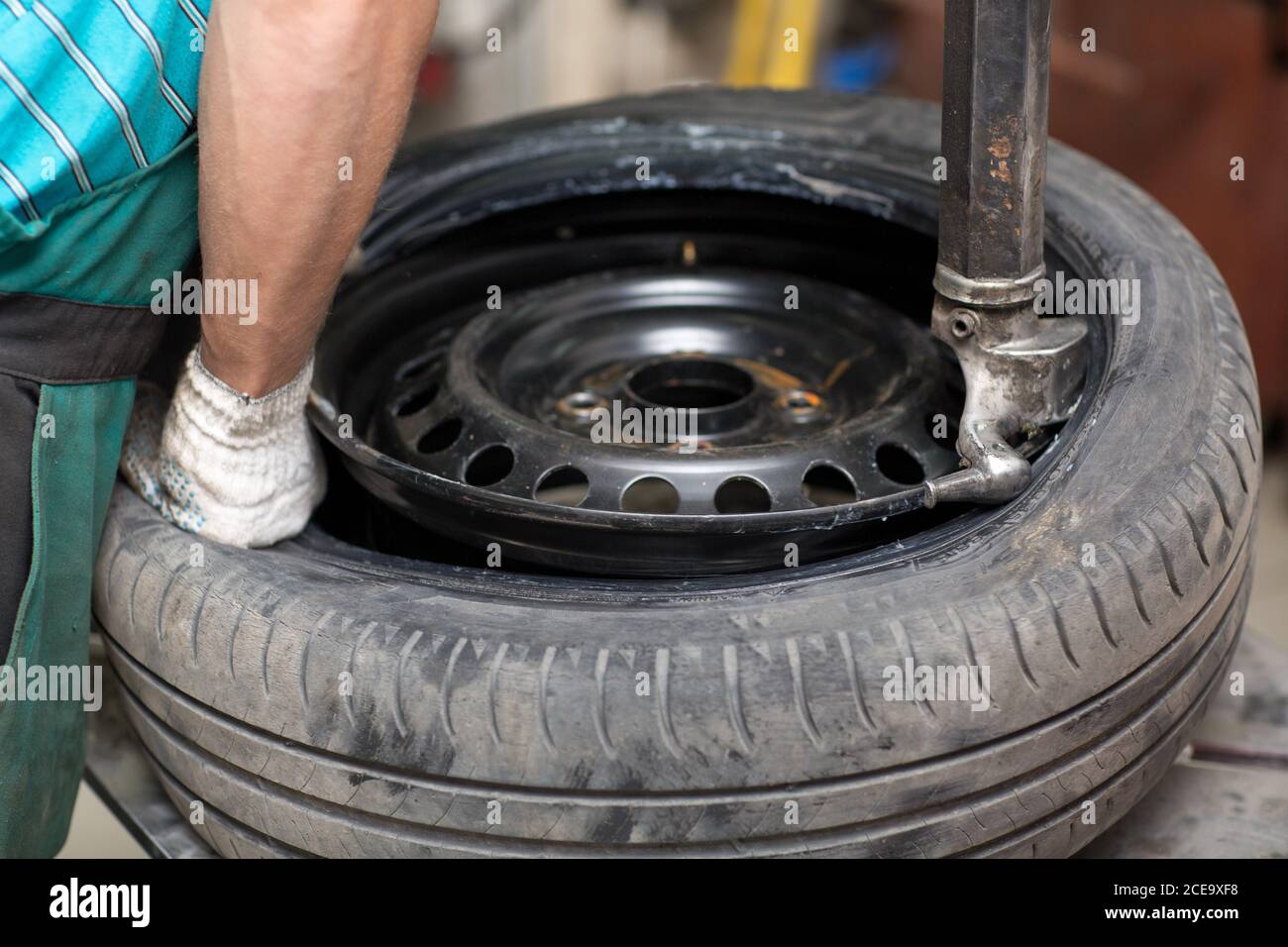 Mechanic changing car tire fitting. Wheel tyre repairing Stock Photo