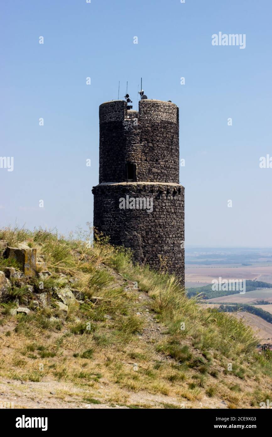 Ruines of hazmburk castle on top of mountain peak of ceske stredohori range. View on the black tower. Stock Photo