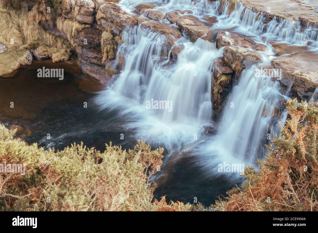 Waterfall on high rocks in autumn Stock Photo