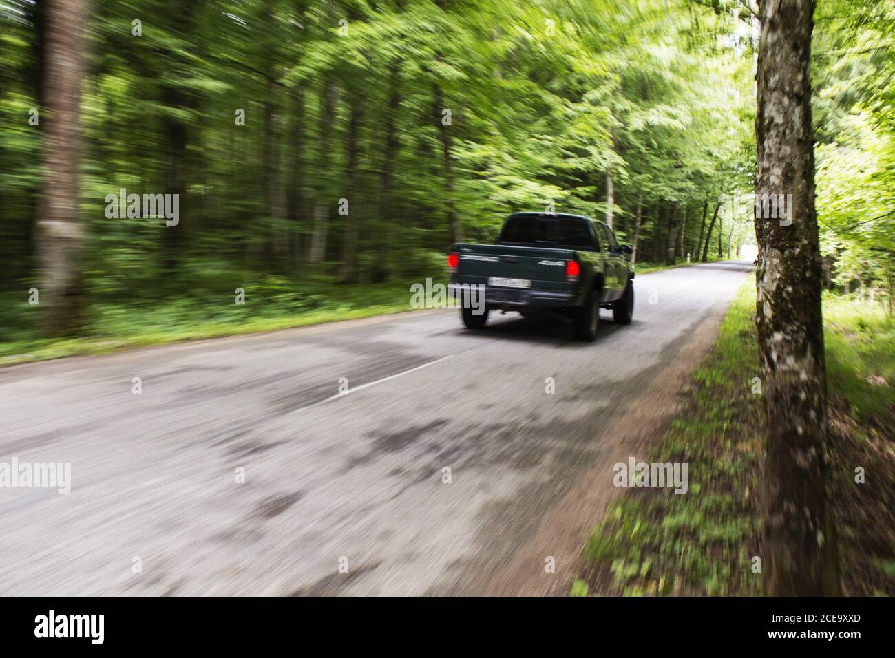 Side view of a black pickup truck in the woods Stock Photo