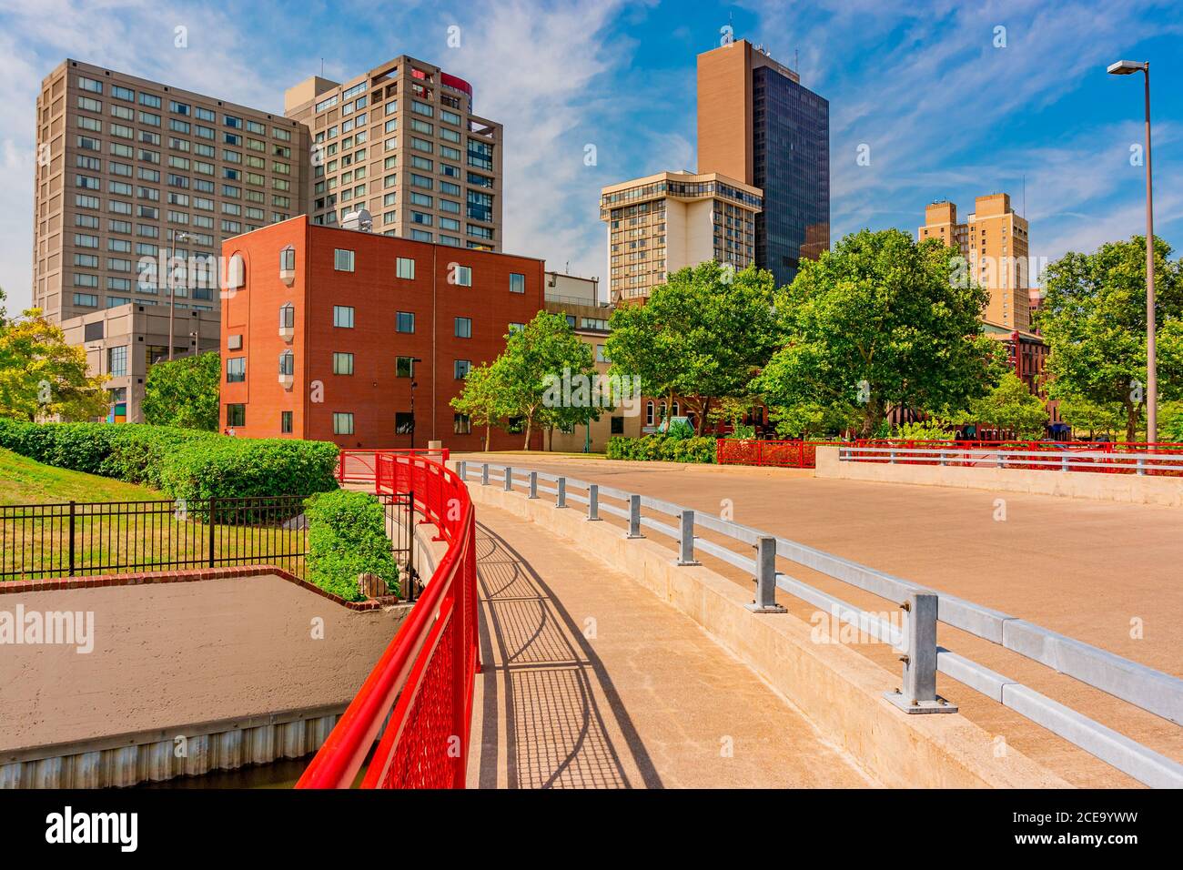 A bridge with bright red railing crosses Swan Creek in downtown Toledo