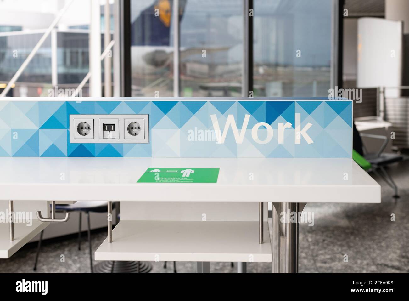Work and connect workbench work space at Frankfurt airport with social distancing reminder sign during coronavirus pandemic, Germany Stock Photo