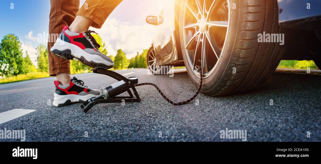 Driver using a foot pump to inflate a tire Stock Photo Alamy