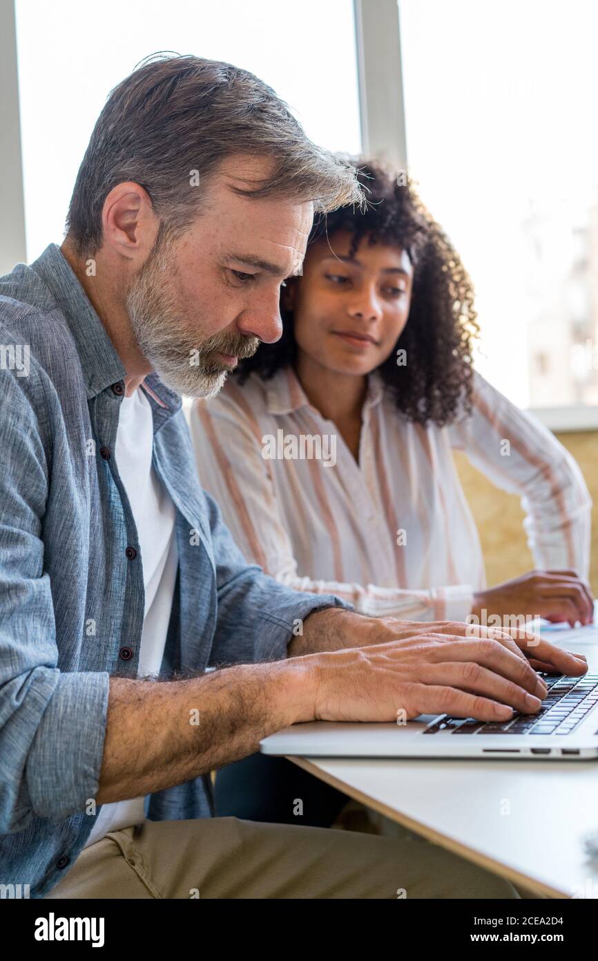 man using laptop near chatting colleagues Stock Photo