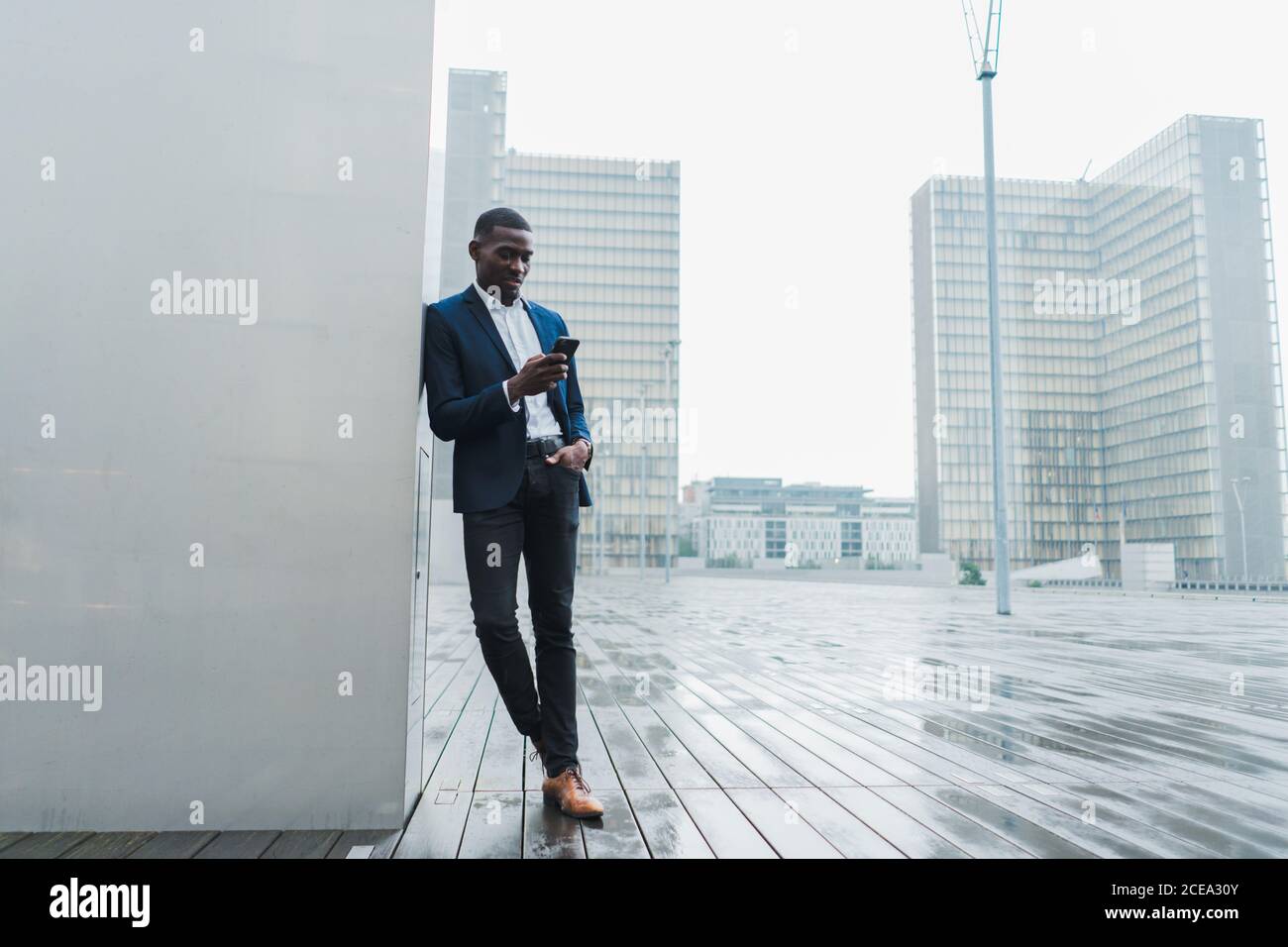 African-American businessman using smartphone standing outdoors Stock Photo