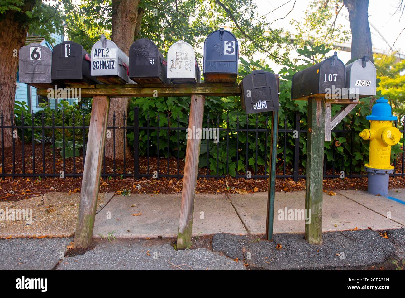 Chesapeake City, MD, USA 08/26/2020: A close up wide angle image of a group of vintage galvanized metal mail boxes on wooden posts. They all have hous Stock Photo