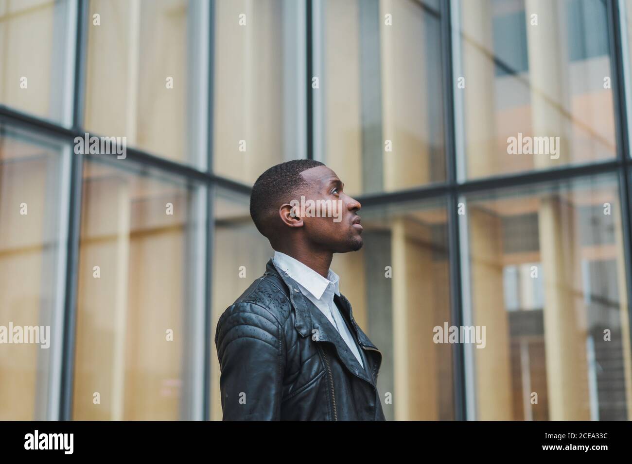 African-American male walking on pavement at building Stock Photo