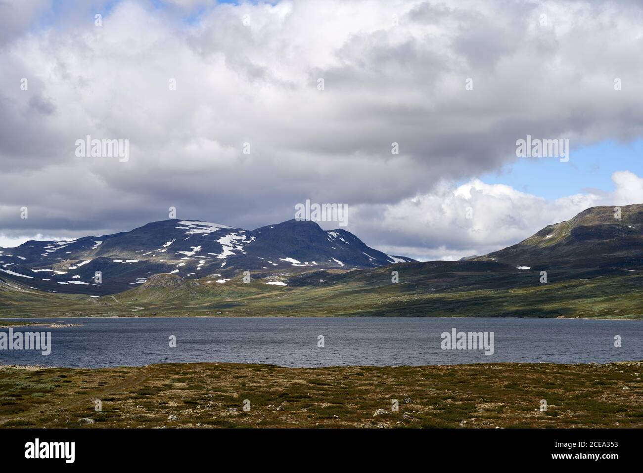 Snow-covered mountains and a lake during the summertime on a highland in Norway, close to Hemsedal Stock Photo