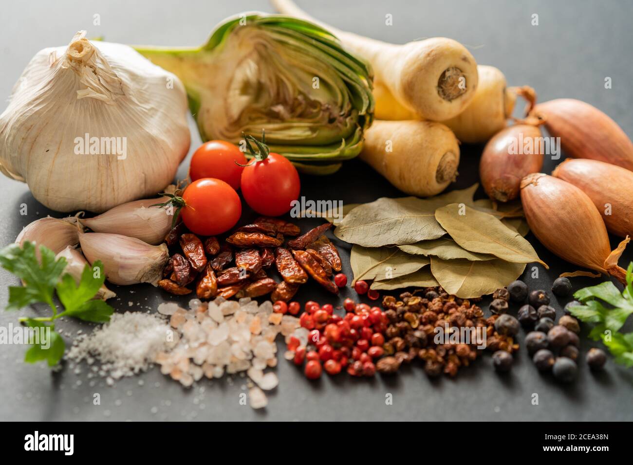 Bunch of assorted ripe vegetables and dried spices lying on gray background Stock Photo