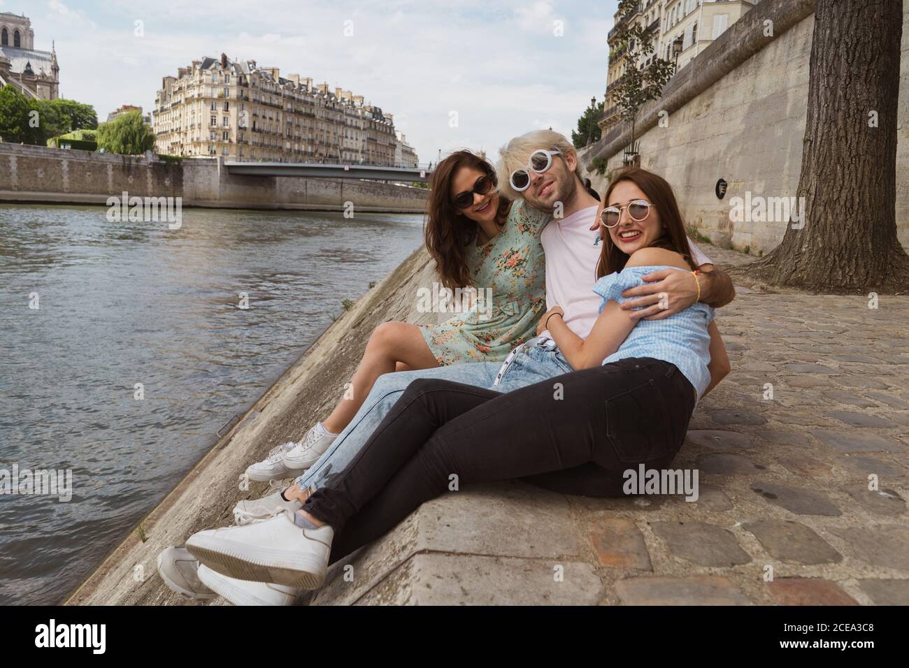 Friends sitting together on waterfront Stock Photo