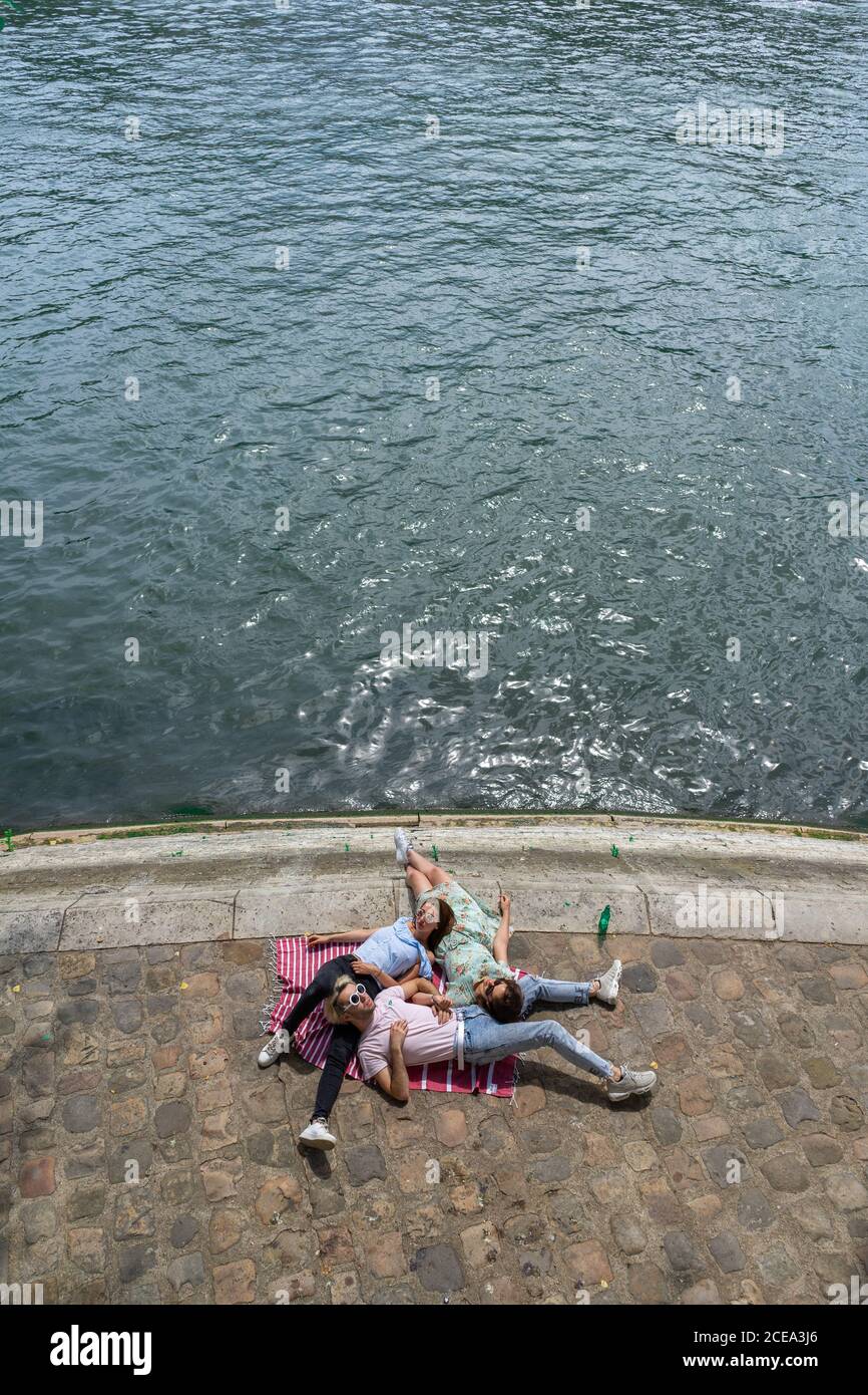 Friends lying on blanket on waterfront Stock Photo