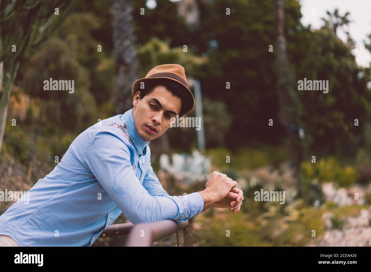 Thoughtful man leaning on handrail Stock Photo