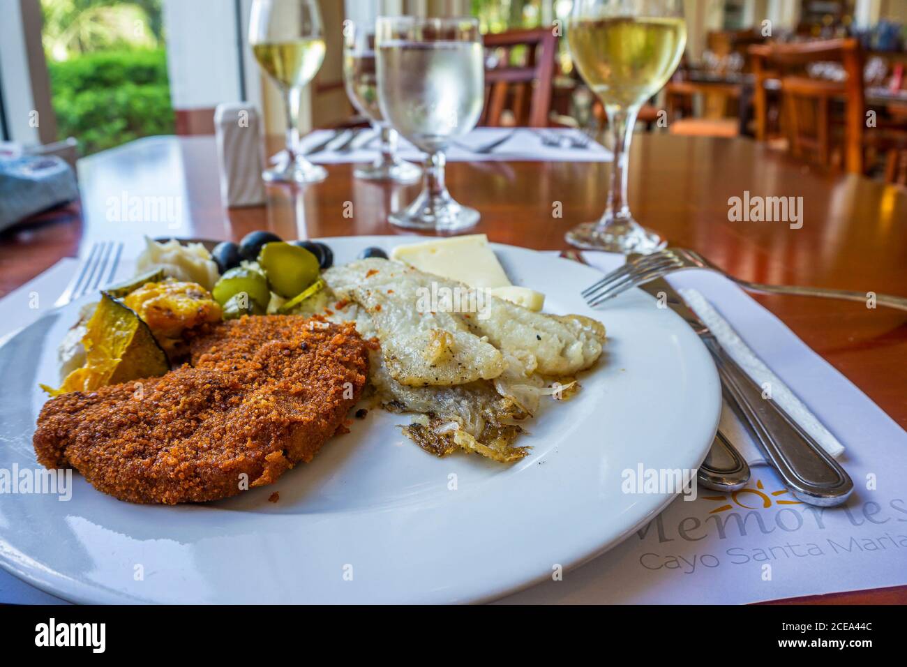 Cayo Santa Maria hotel resort, Cuba, February 2016 - Tasty food on a plate and glass of wine in restaurant. Stock Photo