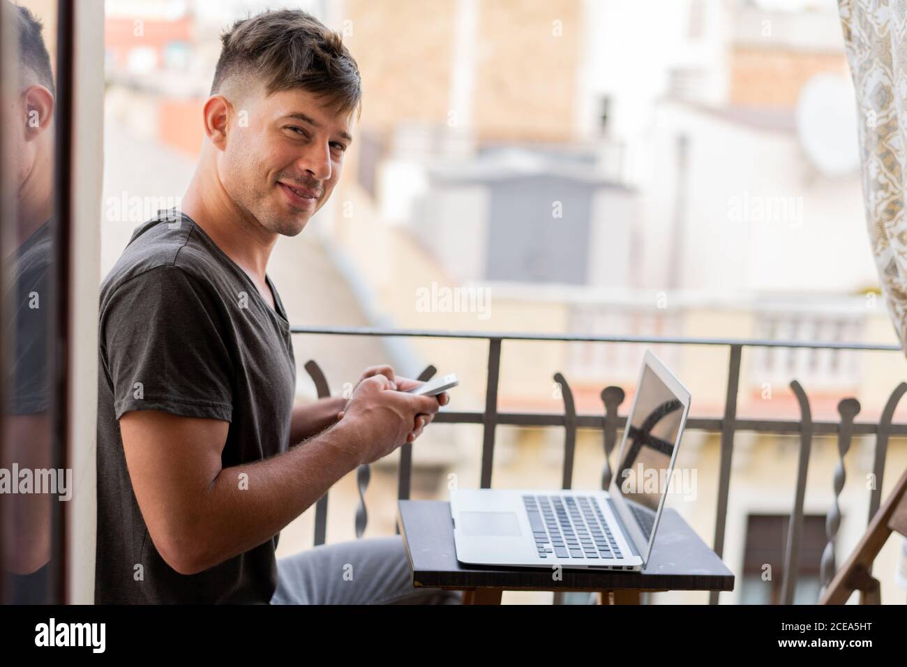 man browsing smartphone and using laptop Stock Photo