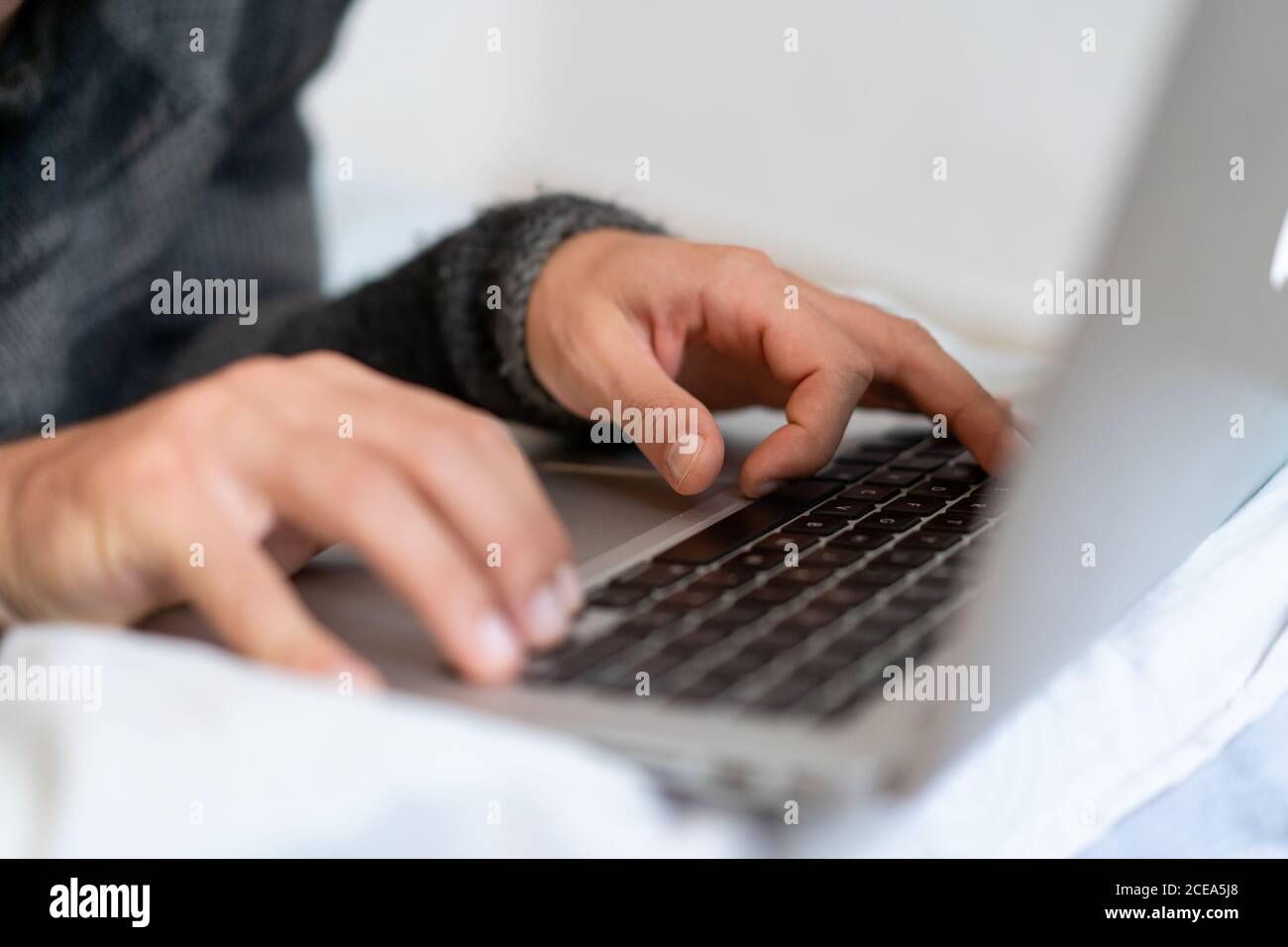 man chilling on bed with laptop Stock Photo