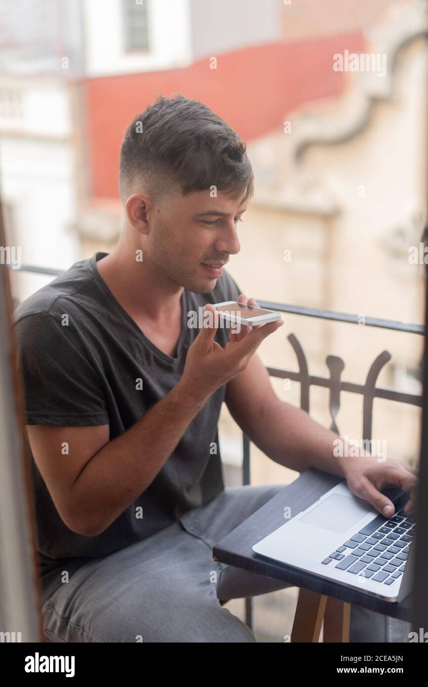 man speaking on phone and using laptop Stock Photo
