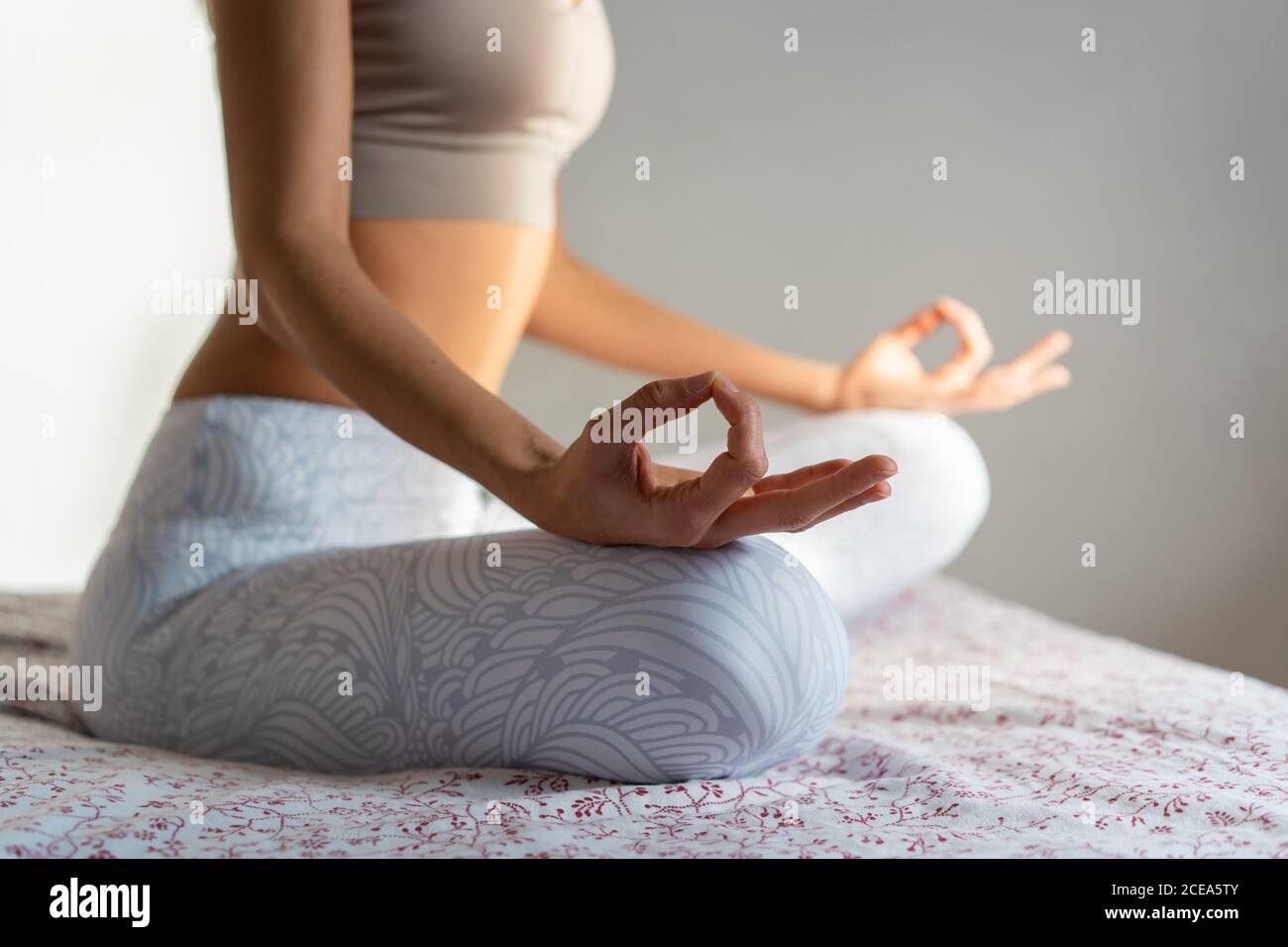 Young Woman meditating on bed Stock Photo