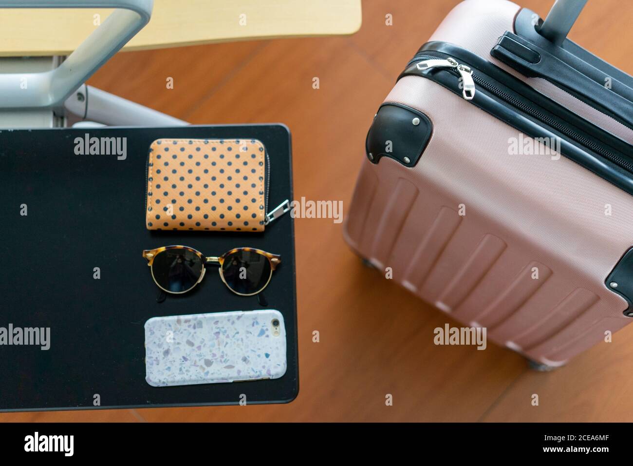 From above rose plastic luggage bag with handle near seat with table with  sunglasses, purse and mobile phone in Porto, Portugal Stock Photo - Alamy