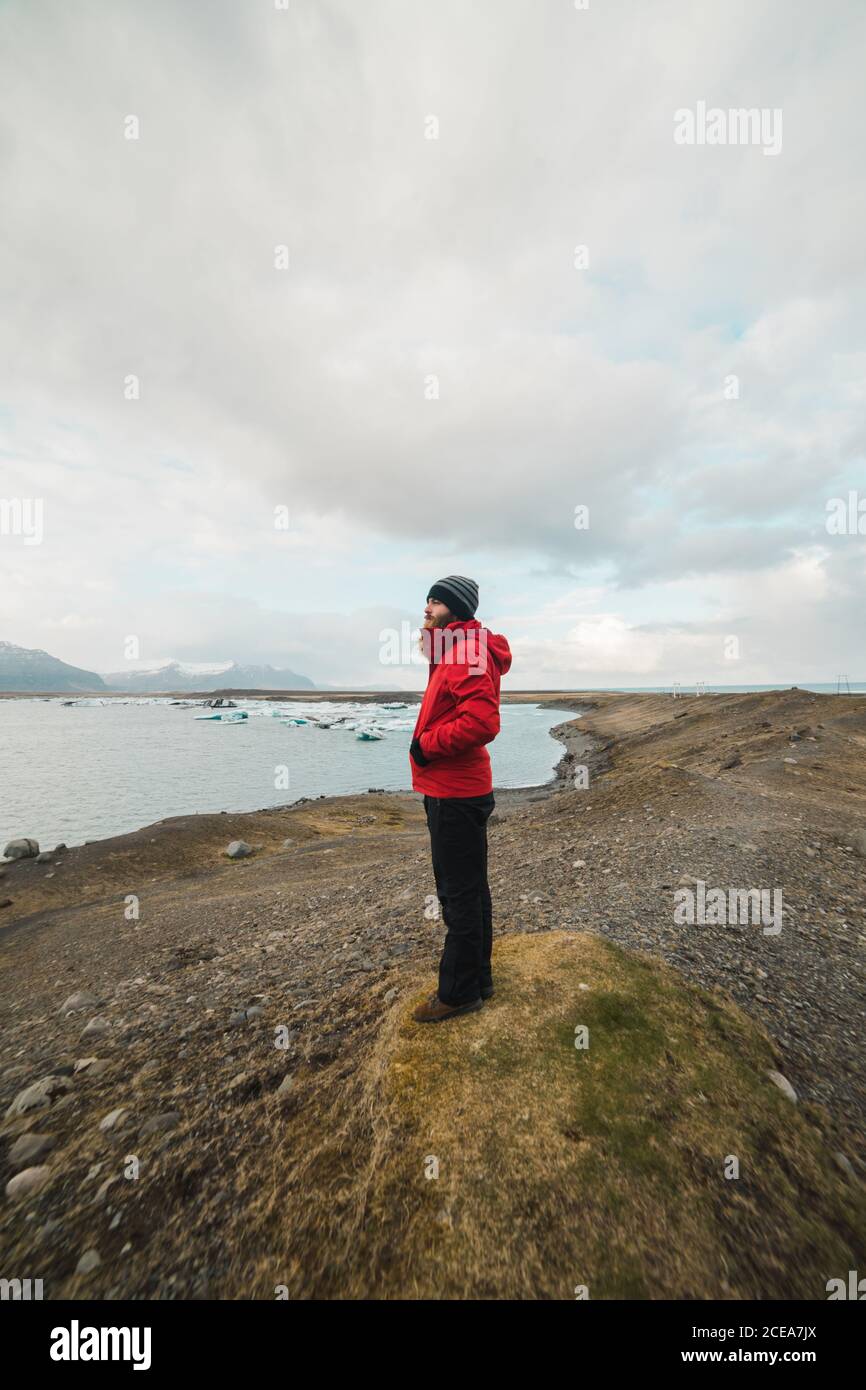 man standing by lake looking away Stock Photo