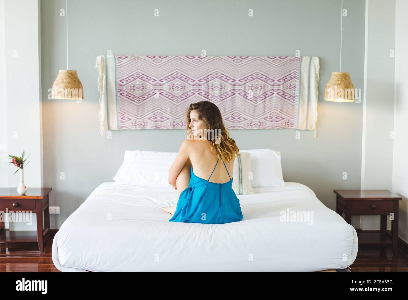 Woman sitting on bed Stock Photo