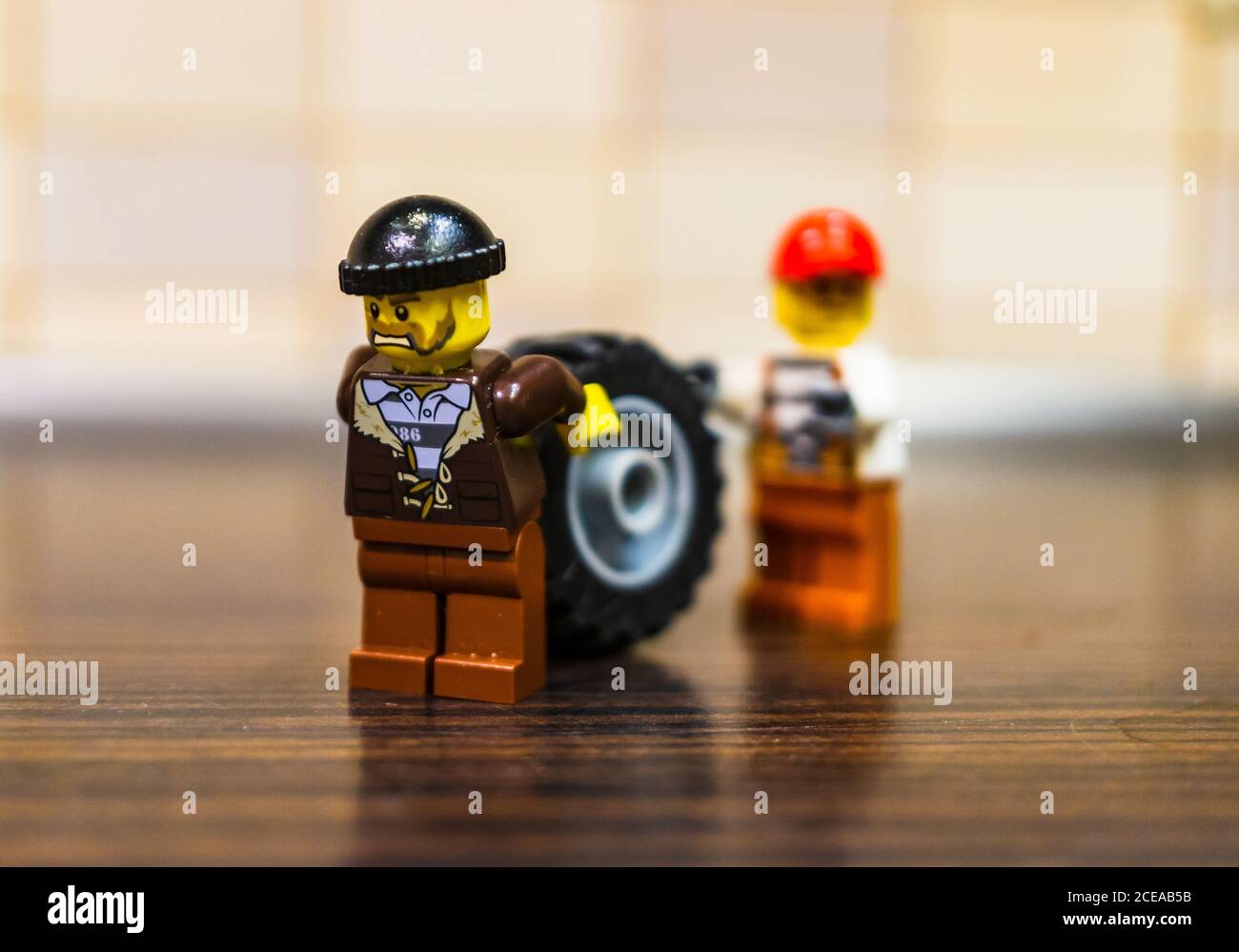 POZNAN, POLAND - Dec 18, 2018: Two Lego thieves figurines moving a car wheel in soft focus back Stock Photo