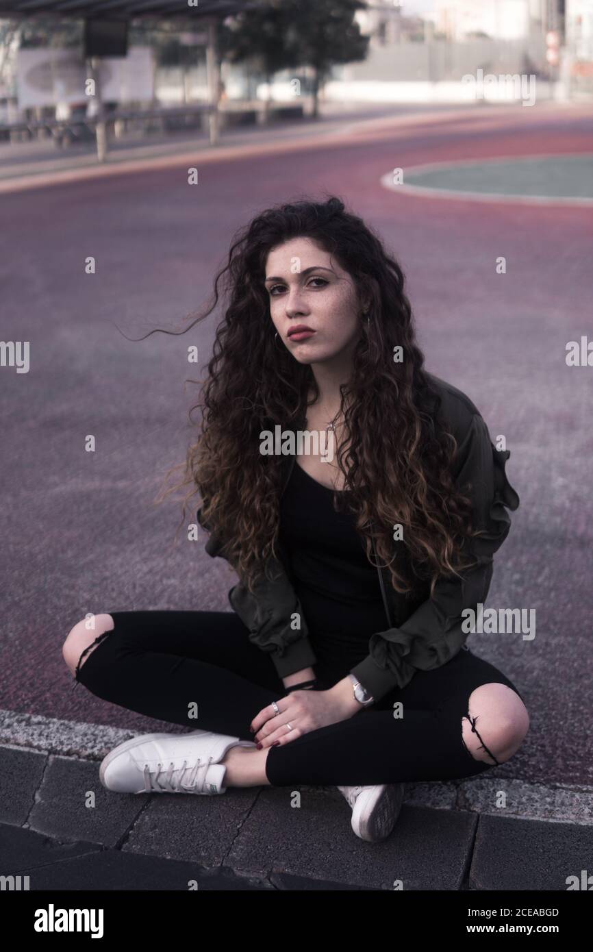 Young Woman sitting on ground Stock Photo - Alamy