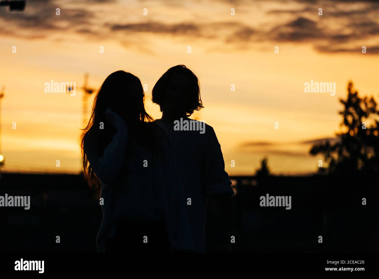 Young guy in sweater near lady in obscurity on street on blurred background Stock Photo