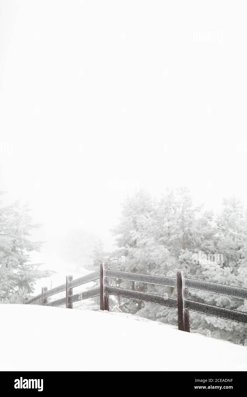 Wooden fence covered with snow standing in magnificent countryside on ...