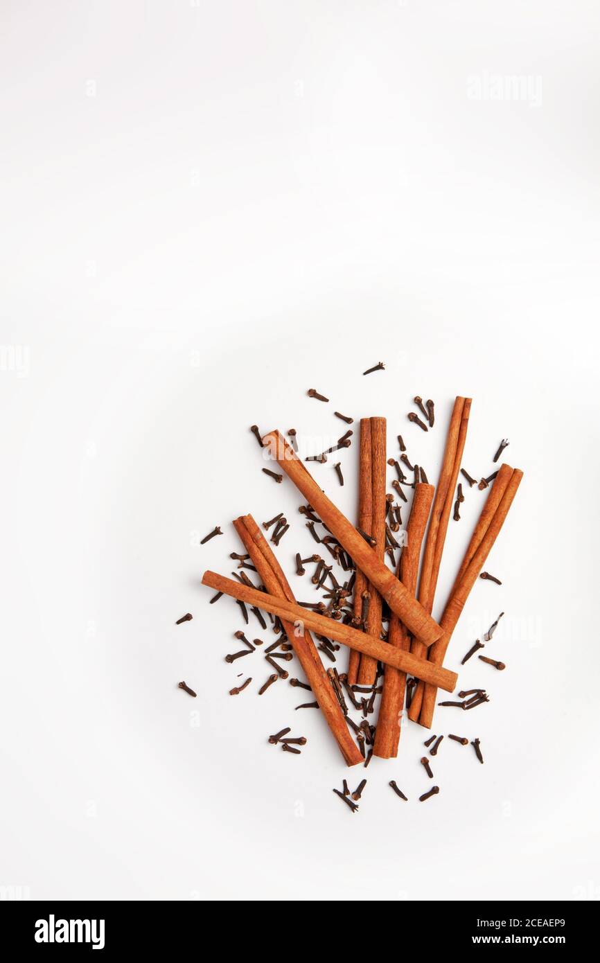 Cinnamon sticks and whole cloves arranged together on a white background Stock Photo