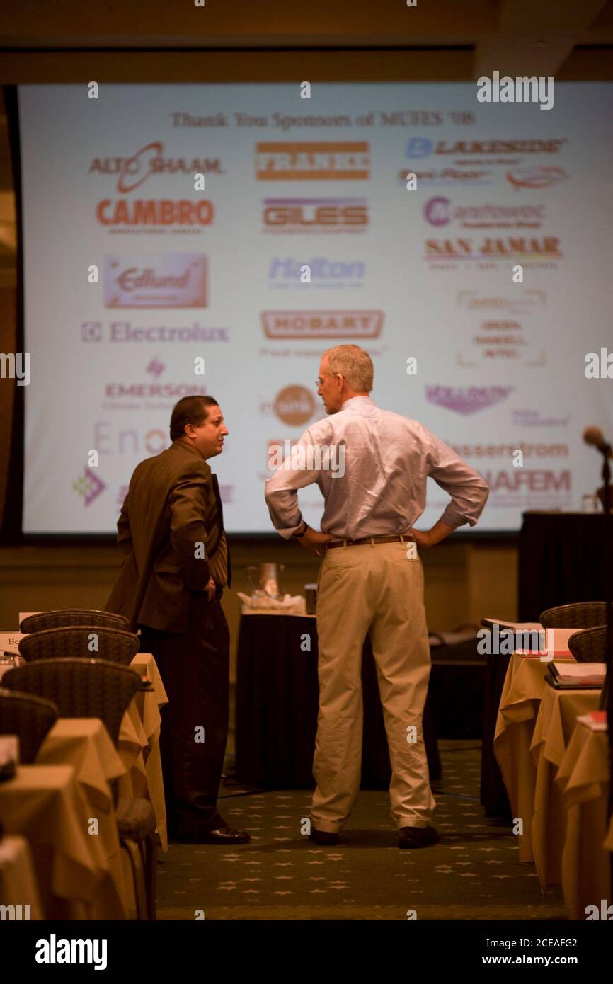 Austin, TX February 17, 2008: Businessmen stand in front of projector screen before education session during trade conference at a suburban golf/spa resort.  Conference sponsors are listed on the screen. ©Bob Daemmrich    EDITORIAL USE ONLY Stock Photo