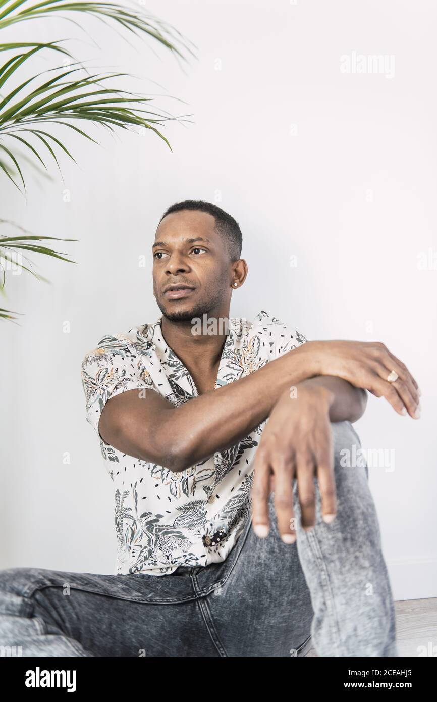 Pensive black man on ground looking away Stock Photo